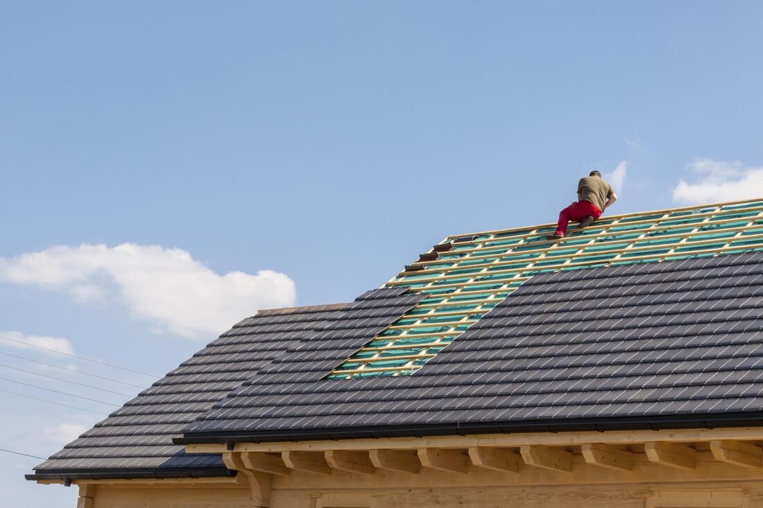 anderson roofer installing ceramic tile roof on a house