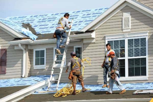 roofers on a ladder working on a shingle roof in anderson indiana